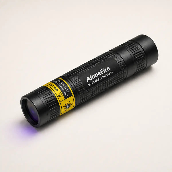 Compact 365nm black light for cat pee beside a cat in a modern home